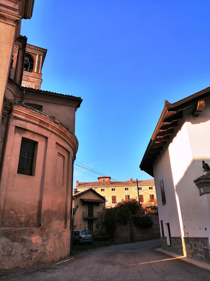 la chiesa parrocchiale di Guazzolo dedicata a Santa Maria e sullo sfondo la casa appartenuta al Conte Vidua